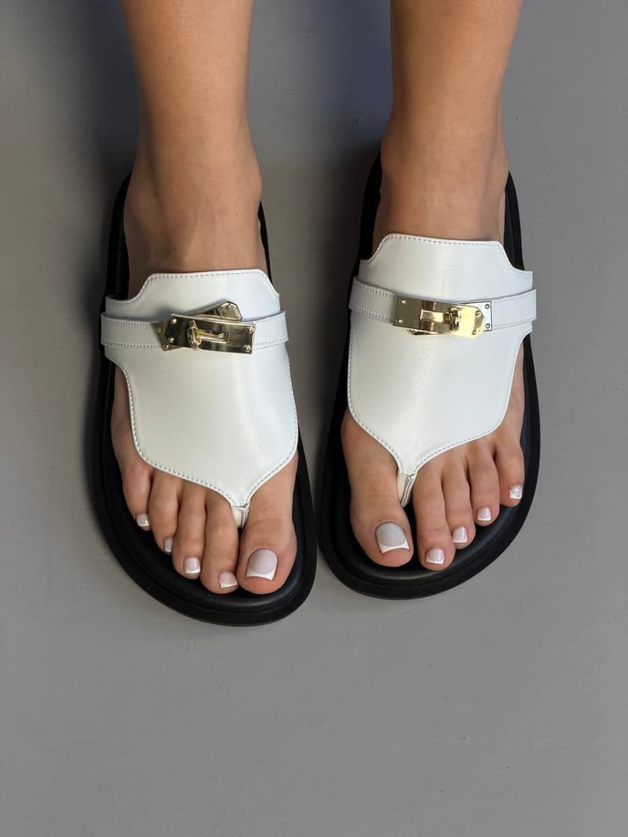 Шльопанці жіночі шкіряні білого кольору на чорній підошві